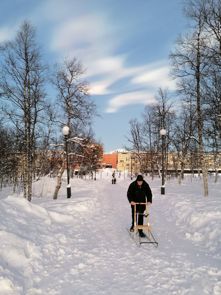 Signore che passeggia con la slitta.